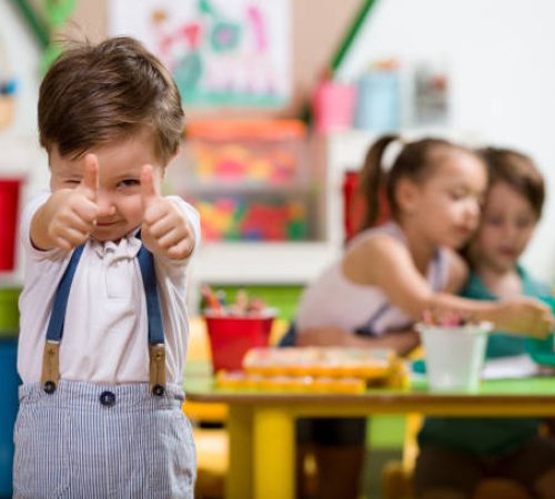 Happy little boy posing in classroom.